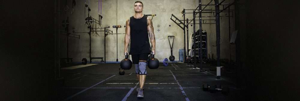 man holding kettlebells in the gym